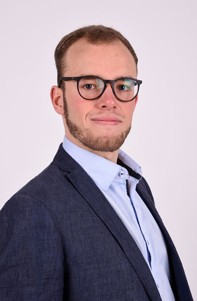 Photo of Sebastian Dix with glasses looking overly serious given the fact he is just an English teacher, not the president of the universe